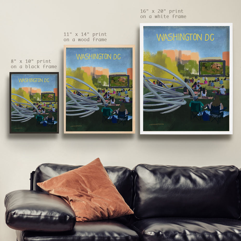 a living room with a black leather couch and two posters on the wall