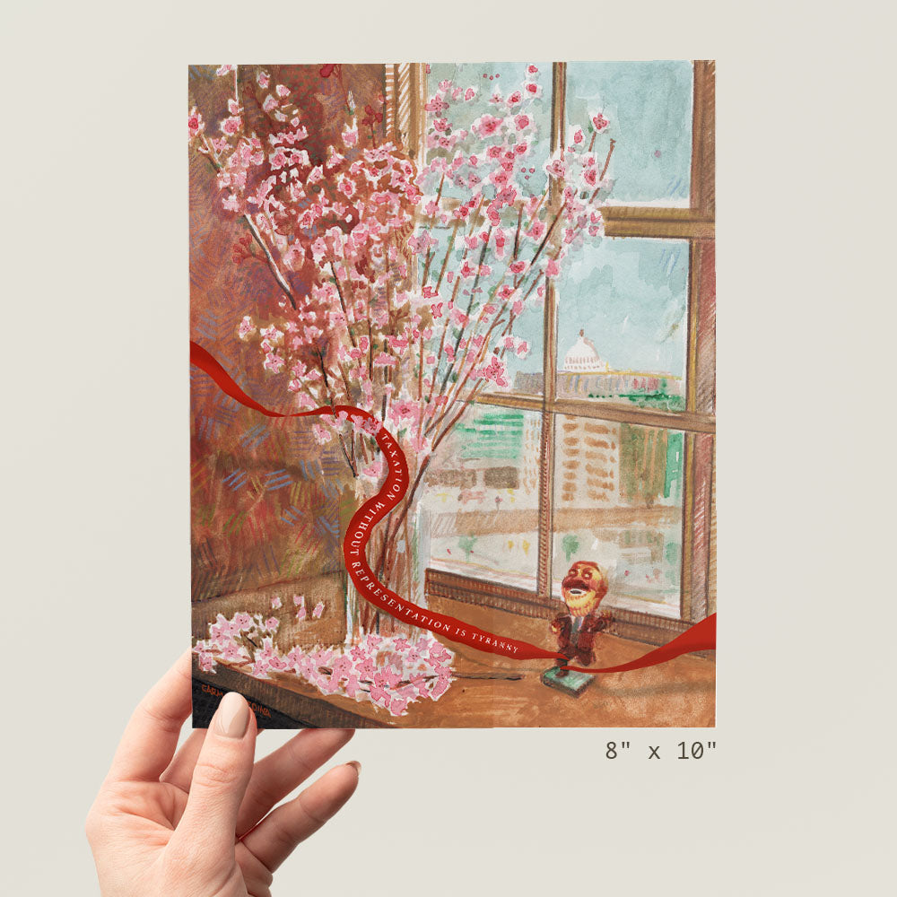 a person holding up a picture of a cherry blossom tree