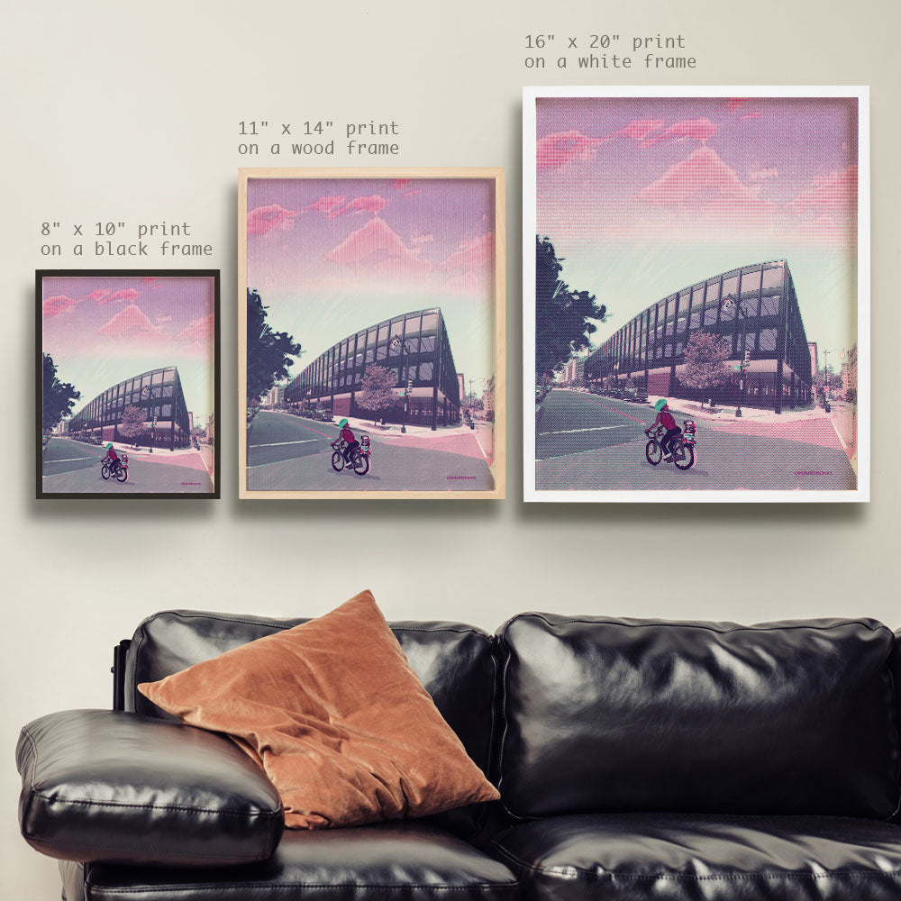 a living room with a black leather couch and two pictures on the wall